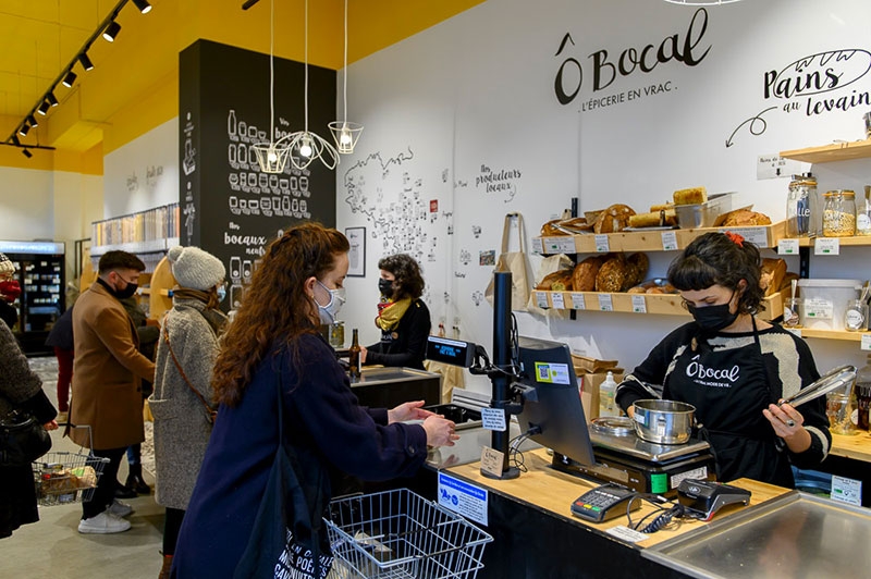 Fanny faisant ses achats dans une boutique de produits en vrac, partenaire de la Galerie. Cette dernière a notamment noué un partenariat avec le réseau des « Boîtes nomades », auquel une vingtaine de restaurants et de traiteurs ont adhéré : ainsi, lorsque vous achetez vos plats à emporter, c’est selon un système de boîtes réutilisables consignées, que vous rapportez. Ce qui évite un nombre incalculable de barquettes, sachets en kraft, et autres contenants, comme habituellement lorsque vous prenez à emporter. Il faut savoir (et on l’apprend à la Galerie : à partir du moment où un emballage est fait à base de plus de deux matériaux, il n’est pas recyclé. « Il n’existe aucune usine en France qui recycle autre chose que les bouteilles et les flacons. Nous n’avons ni les usines ni les filières », indique Christian. Aucun emballage alimentaire n’est donc recyclé, même ceux qui semblent très « écolo » !