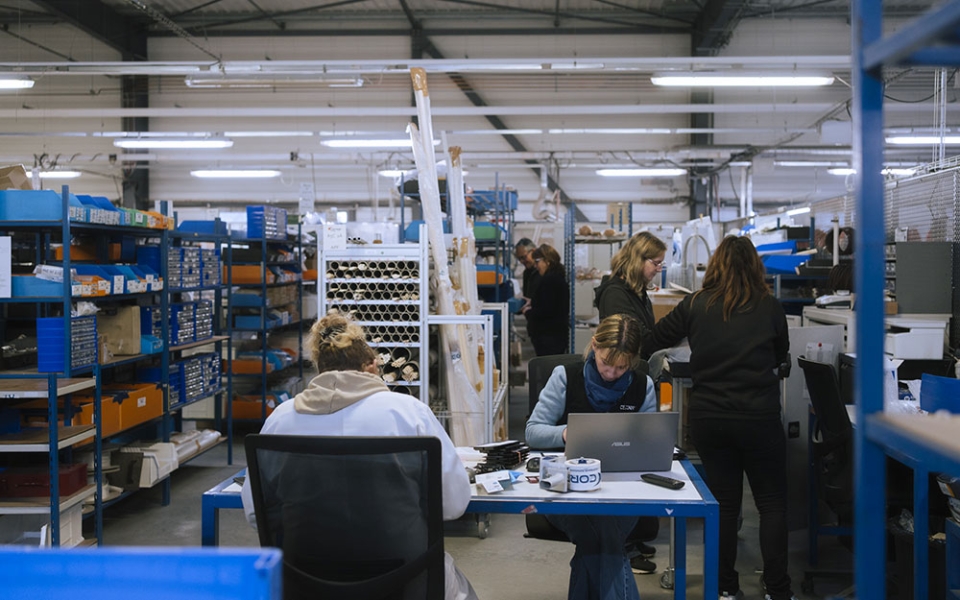 Toute la production est assurée sur place. Le flux est organisé en forme de U, avec une zone de réception des composants, plusieurs ateliers d’assemblage spécialisés, une zone de contrôle final et une zone d’expédition.