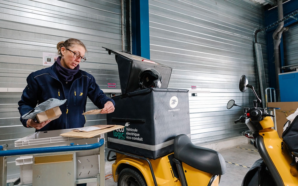 « Ce que j’apprécie particulièrement dans ce métier, c’est d’être autonome », souligne-t-elle dans un sourire en chargeant son Staby (scooter électrique à trois roues). « Ce que j’aime le moins ? C’est quand il pleut. »