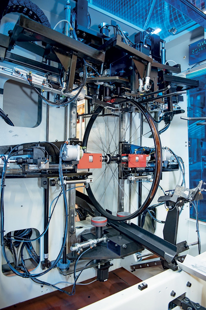 En 2019, Moustache a relocalisé la fabrication des roues. L’entreprise a investi 250 000 euros pour pouvoir maîtriser la qualité d’assemblage. Un opérateur insère les rayons dans le moyeu ; une machine rayonne automatiquement la roue, une autre adapte la tension des rayons. L’opérateur n’a plus qu’à monter les pneus et les disques de frein.