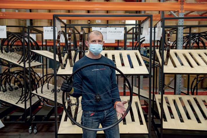 En 2019, Moustache a relocalisé la fabrication des roues. L’entreprise a investi 250 000 euros pour pouvoir maîtriser la qualité d’assemblage. Un opérateur insère les rayons dans le moyeu ; une machine rayonne automatiquement la roue, une autre adapte la tension des rayons. L’opérateur n’a plus qu’à monter les pneus et les disques de frein.