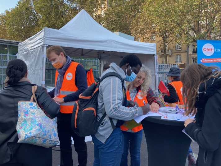 Sur ce point-rencontre situé à proximité de la gare RER parisienne Denfert-Rochereau, deux sujets interpellent les passants : la reconversion et le logement. Des salariés remplissent le questionnaire élaboré par l’Union régionale interprofessionnelle d’Île-de-France dans le cadre de sa grande enquête « Causons logement. » D’autres recueillent auprès des militants des informations à propos du conseil en évolution professionnelle (CEP), première étape d’une démarche de reconversion.