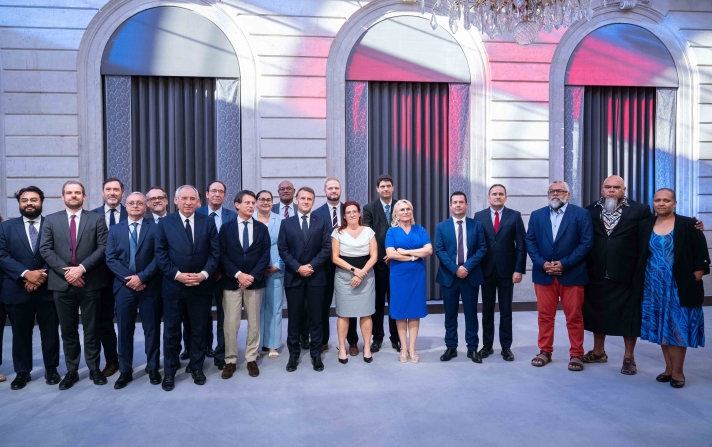 François Bayrou, Premier ministre, Manuel Valls, ministre des Outre-mer, et Emmanuel Macron, président de la République, le 12 juillet 2025 à l’Élysée, avec les négociateurs lors de la conclusion du Sommet pour l’avenir de la Nouvelle-Calédonie.