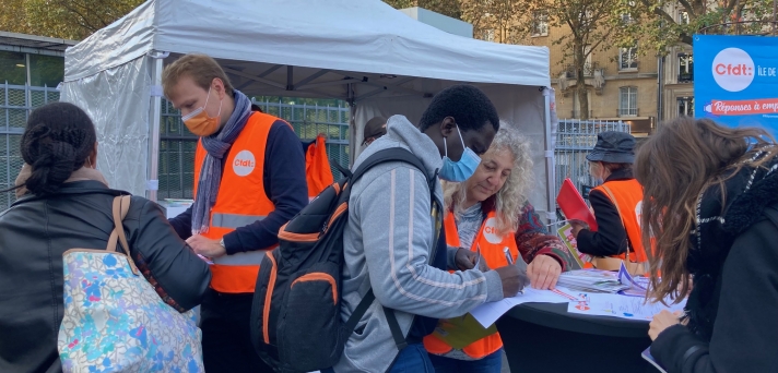 Sur ce point-rencontre situé à proximité de la gare RER parisienne Denfert-Rochereau, deux sujets interpellent les passants : la reconversion et le logement. Des salariés remplissent le questionnaire élaboré par l’Union régionale interprofessionnelle d’Île-de-France dans le cadre de sa grande enquête « Causons logement. » D’autres recueillent auprès des militants des informations à propos du conseil en évolution professionnelle (CEP), première étape d’une démarche de reconversion.