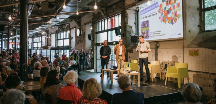 À la tribune, au micro, Christophe Robert, porte-parole du Pacte du pouvoir de vivre et délégué général de la Fondation pour le logement des défavorisés ; à ses côtés, Pierre Rosanvallon, historien et sociologue, créateur en 2002 de La République des idées.