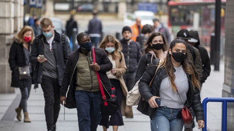 Des citadins marchent, masqués et préoccupés