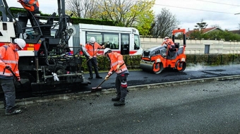 Cantonniers au travail pour goudronner une route.