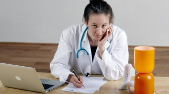 Femme médecin avec stéthoscope en train d’écrire